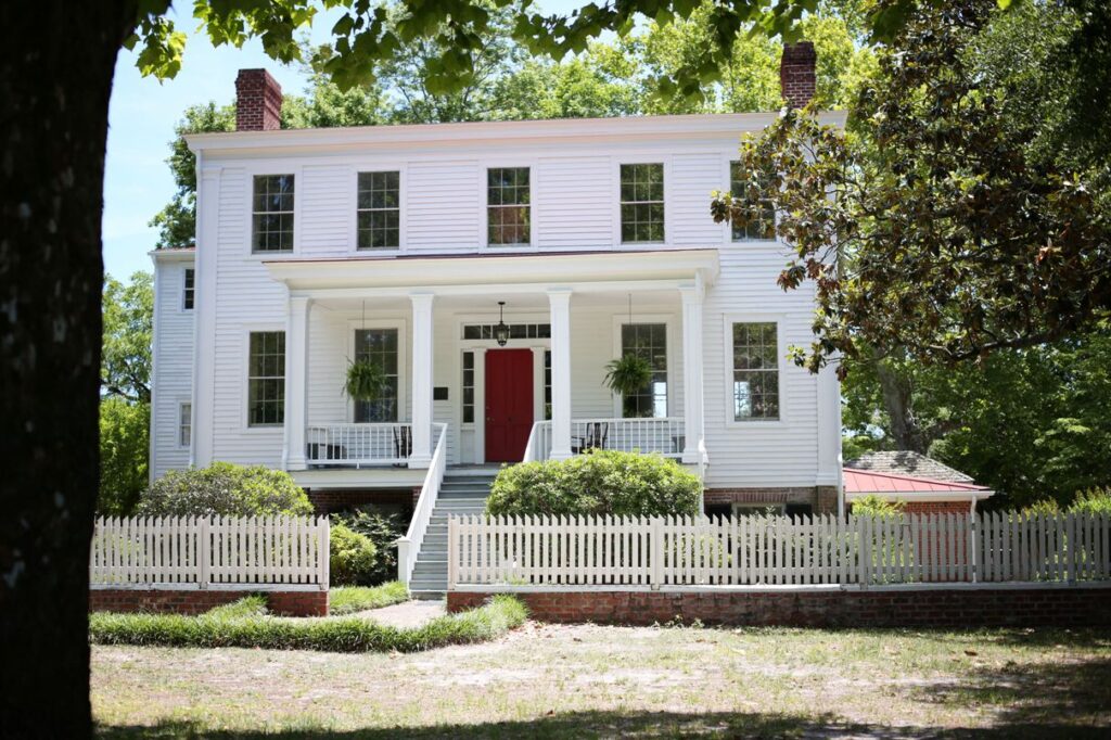 The Poplar Grove manor house, white clapboard with a red front door