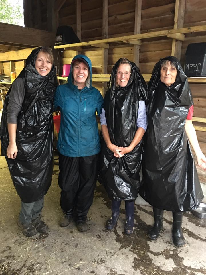 Four stable volunteers in wet-weather gear